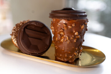 Chocolate Coffee Cup Dessert with Nut Coating on a Golden Tra