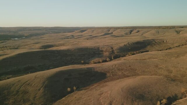 Vast dry hills and ravines at sunset in a wide open landscape