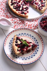 Piece of delicious currant pie served on white wooden table