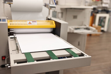 Modern roll laminator with paper indoors, closeup. Printing house