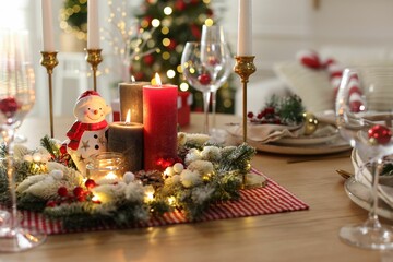 Christmas place setting with festive decor on wooden table in room
