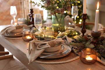 Christmas place setting with festive decor on wooden table in room