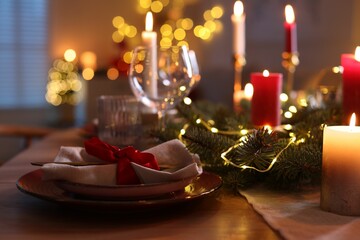 Festive table setting in room decorated for Christmas, closeup. Bokeh effect © New Africa