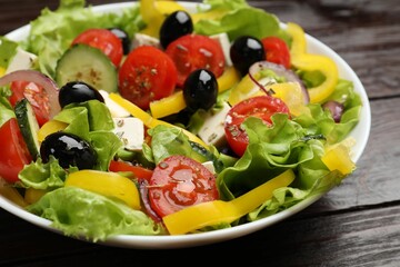 Delicious fresh Greek salad on wooden table, closeup