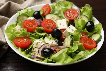 Delicious fresh Greek salad on wooden table, closeup