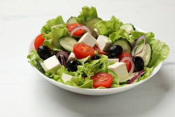 Delicious fresh Greek salad on white table, closeup