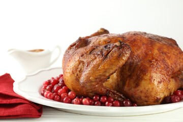 Delicious baked turkey and cranberries on white wooden table, closeup