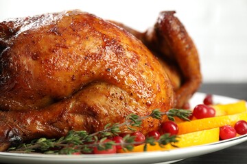 Delicious baked turkey, orange slices, cranberries and thyme on table, closeup