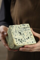 Woman with piece of delicious cheese, closeup