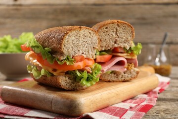 Delicious sandwiches with ham on wooden table, closeup