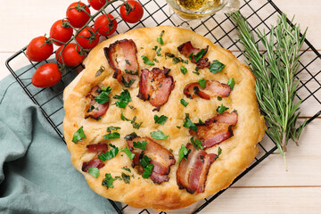 Delicious focaccia bread with bacon and parsley on white wooden table, flat lay