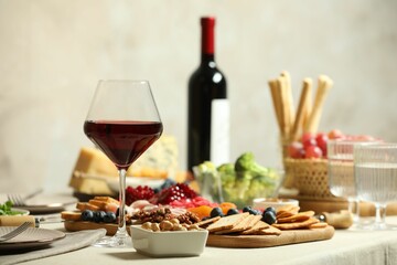 Red wine and different snacks served on table