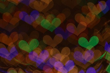 Blurred view of heart shaped lights on dark background, bokeh effect