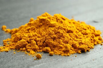 Heap of turmeric powder on grey table, closeup