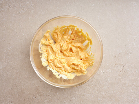A creamy mixture for deviled eggs is being prepared in a clear bowl, showcasing a smooth, rich texture. This step is crucial for making flavorful appetizers