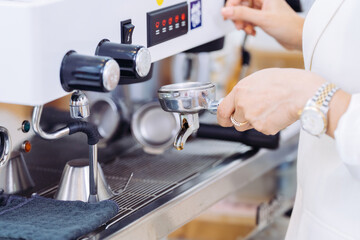 Close-up of the owner's hand, a female executive, making a coffee menu with a machine. She has a good vision and can grow her business in the advanced future world.