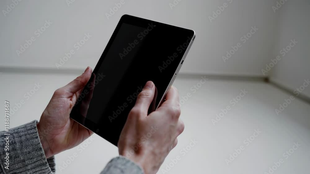 Poster black tablet held vertically, featuring a blank screen, combining minimalism and functionality