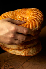 Baker's hand holding a loaf of freshly baked white bread