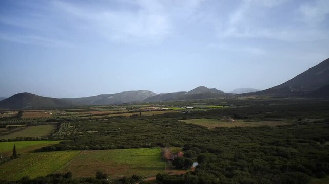 Aerial footage of a road passing through the green fields of Tithorea town in Phthiotis, Greece