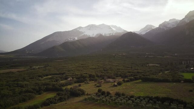 Aerial footage of the green fields of Tithorea town in Phthiotis, Greece, on a sunny day