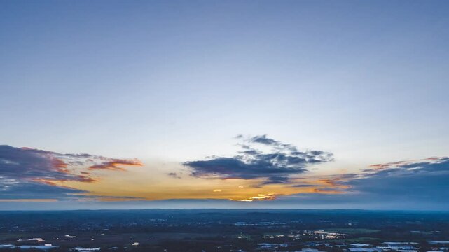 Time-lapse pull-back aerial footage of the clouds moving over South Acton area, England, at sunset