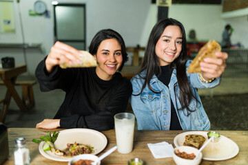Two friends savoring tasty tacos and drinks at an authentic mexican taqueria, highlighting the bold...