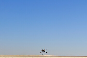 two friends enjoing life together on the building roof in front of blue sky