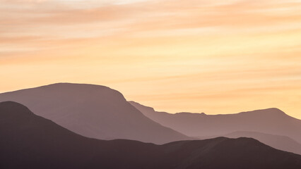 Beautiful pastel peaceful landscape image of layered mountains during soft Autumn sunset in Lake District