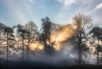 Stunning dramatic atmospheric sunburst glow at sunrise around River Brathay in Lake District in Autumn