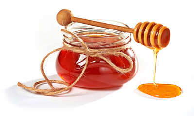 Słoik miodu z drewnianą łyżką w tle, naturalny produkt na białym tle