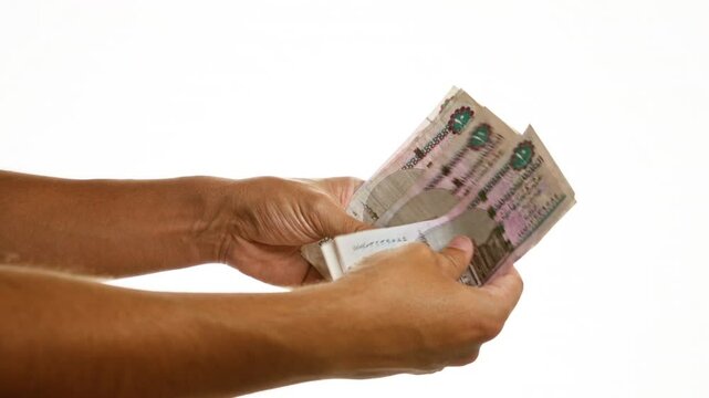 Hands holding egyptian pounds over isolated white background demonstrating currency and finance concepts