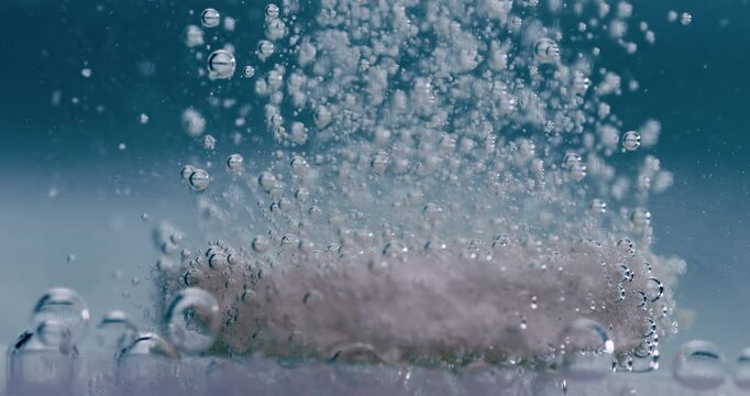 Extreme Close-up effervescent tablet, pill bubbling underwater. Shot on super slow motion camera 1000 fps.