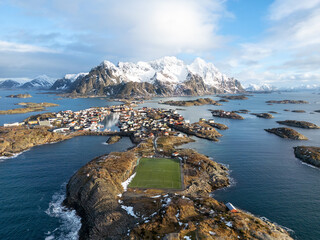 Aerial shot of a soccer field on an island with mountains in the background, winter time in Norway © DVS - Drone Visuals