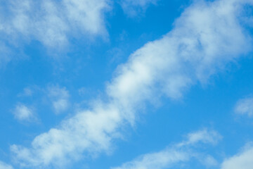 Blue sky with fluffy clouds. Celestial calm background, pure colors.