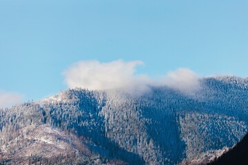 Snow blankets the peaks of towering mountains, contrasting beautifully with the vibrant blue sky...