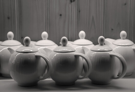 Viele Kaffekannen stehen in einem Fach nebeneinander.
