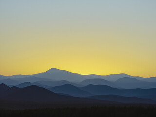 a serene and minimalistic sunset over a silhouette of distant mountains.