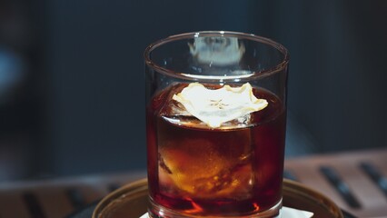 Closeup cocktail whiskey in Old fashioned with cube ice decorated dried sliced apple on top making special drink list, advertisement focusing alcohol refreshing showcase copy space at club. Vinosity.