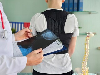 Therapist physiologist correcting corset on patient in clinic concept