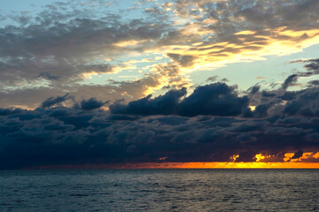 Fototapeta premium Red sunset over the sea, rich in dark clouds, rays of light. Black Sea coast, early autumn