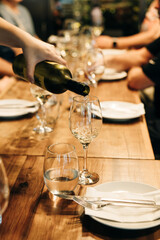 tableware Glasses, flower fork, knife served for dinner in restaurant with cozy interior