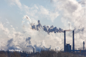 A large cloud of smoke is rising from a factory