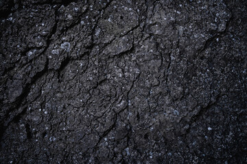 Fototapeta premium Dark stone texture background. Close up of limestone rock wall. Clay surface with cracks. Modern dark gray grunge background with space for design. Granite. Slab. Nature Backdrop. Wallpaper.