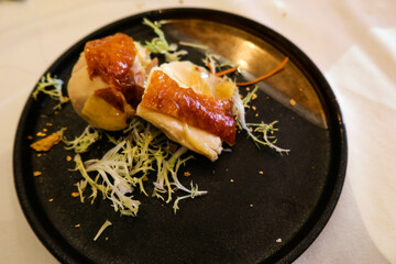 close up of Chinese two pieces of grill chickens on a black plate