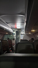 Airplane Cabin View with Passenger Seats and Cockpit Door at Night