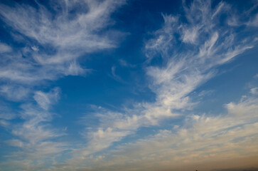 Obraz premium Vibrant sky painted with wispy clouds during a serene sunset over a tranquil horizon