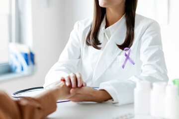 Female doctor in white coat with purple ribbon talking with patient. Alzheimer's disease, Pancreatic cancer, Hodgkin's Lymphoma awareness