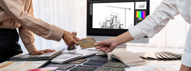 Group of interior architect designer team at table choosing various mood board samples with...