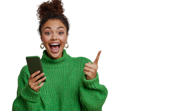 Excited Indian woman in a mint green kurta holding a smartphone horizontally, pointing at the screen with a joyful expression, set against a white background.

