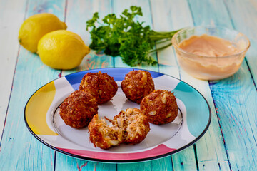 plate of crispy fried crab meatball fritters served with fresh parsley and lemon